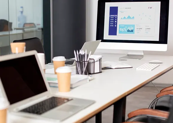 Meeting table with laptops and a monitor